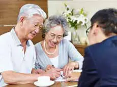 Businessman showing forms to senior couple
