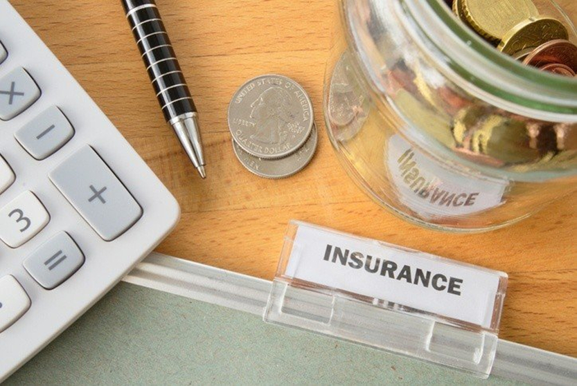 A pen, calculator and coin are on the table.